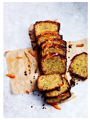 Photograph of Lemon Drizzle cake cut into slices on baking paper.