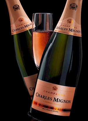 Photograph of two bottles of pink champagne with a glass of champagne