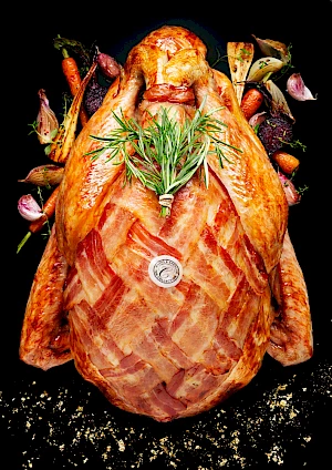 Photograph of M&S Christmas Turkey with roasted vegetable and rosemary garnish