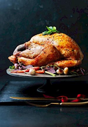Photograph of Christmas turkey on a platter with roast vegetables