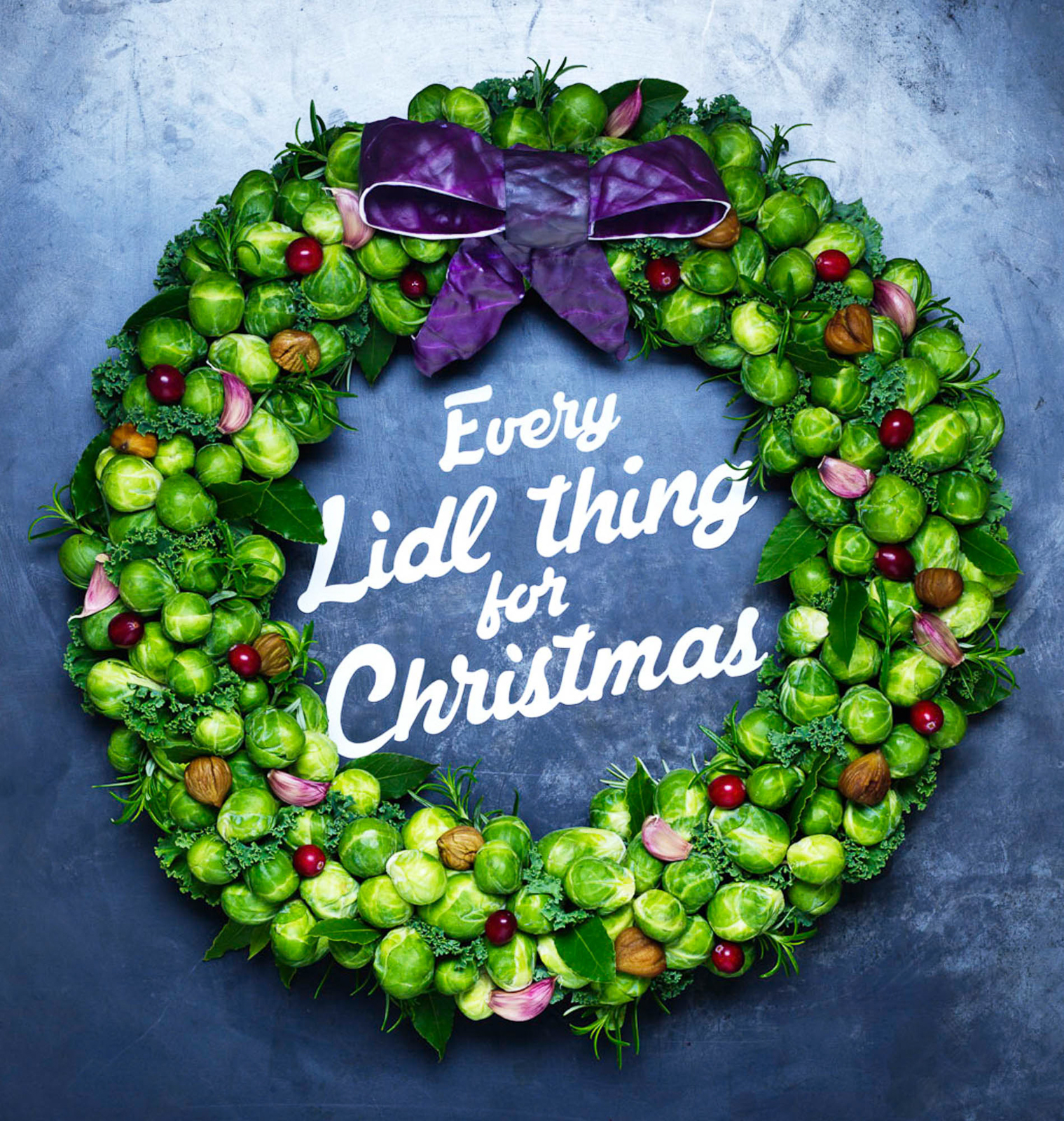 Photograph of a sprout wreath with cranberries, red cabbage ribbon, garlic, chestnuts and rosemary