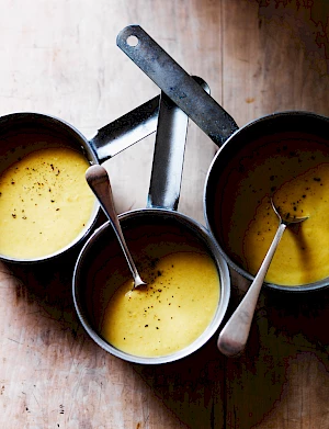 Photograph of Sybil Kapoor's Spiced Parsnip Soup from Simply Veg by Anova. Pans of soup