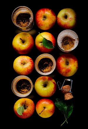 Photograph of Normandy Apple Juice in glasses shown in rows with apples