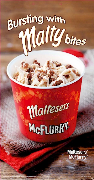 Advert for Maltese's McFlurry. Photograph of a Maltesers McFlurry on a red and brown napkins with wood background.