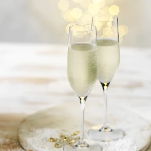 Photograph of champagne flutes of cava with Christmas fairy lights