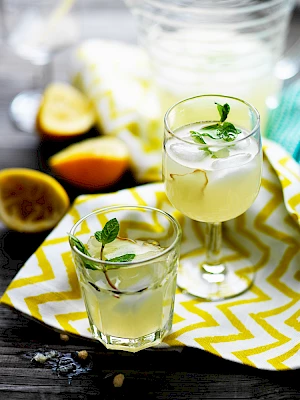 Photograph of Mint and ginger lemonade with mint garnish and squeezed lemons