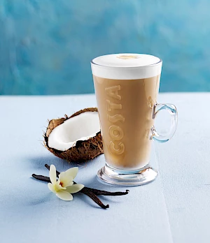 Costa Coconut and Vanilla Latte on Pale Blue Background with Vanilla Flower