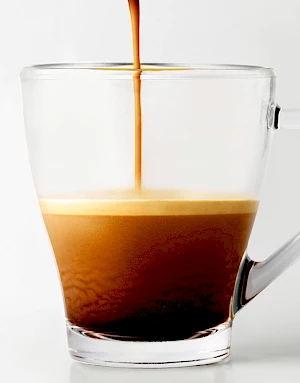 Coffee Pour into Glass Cup with Crema Rising
