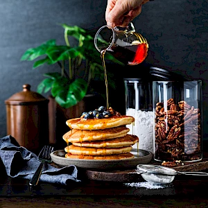 Franklin Lade Glass jars with panckakes and pouring maple syrup