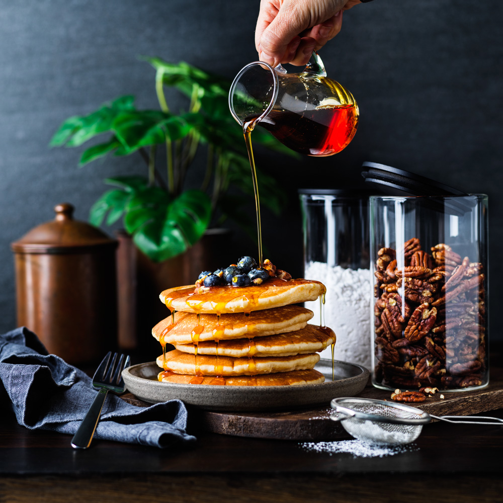 Franklin Lade Glass jars with panckakes and pouring maple syrup